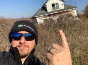 A Man Pointing at an Abandoned House